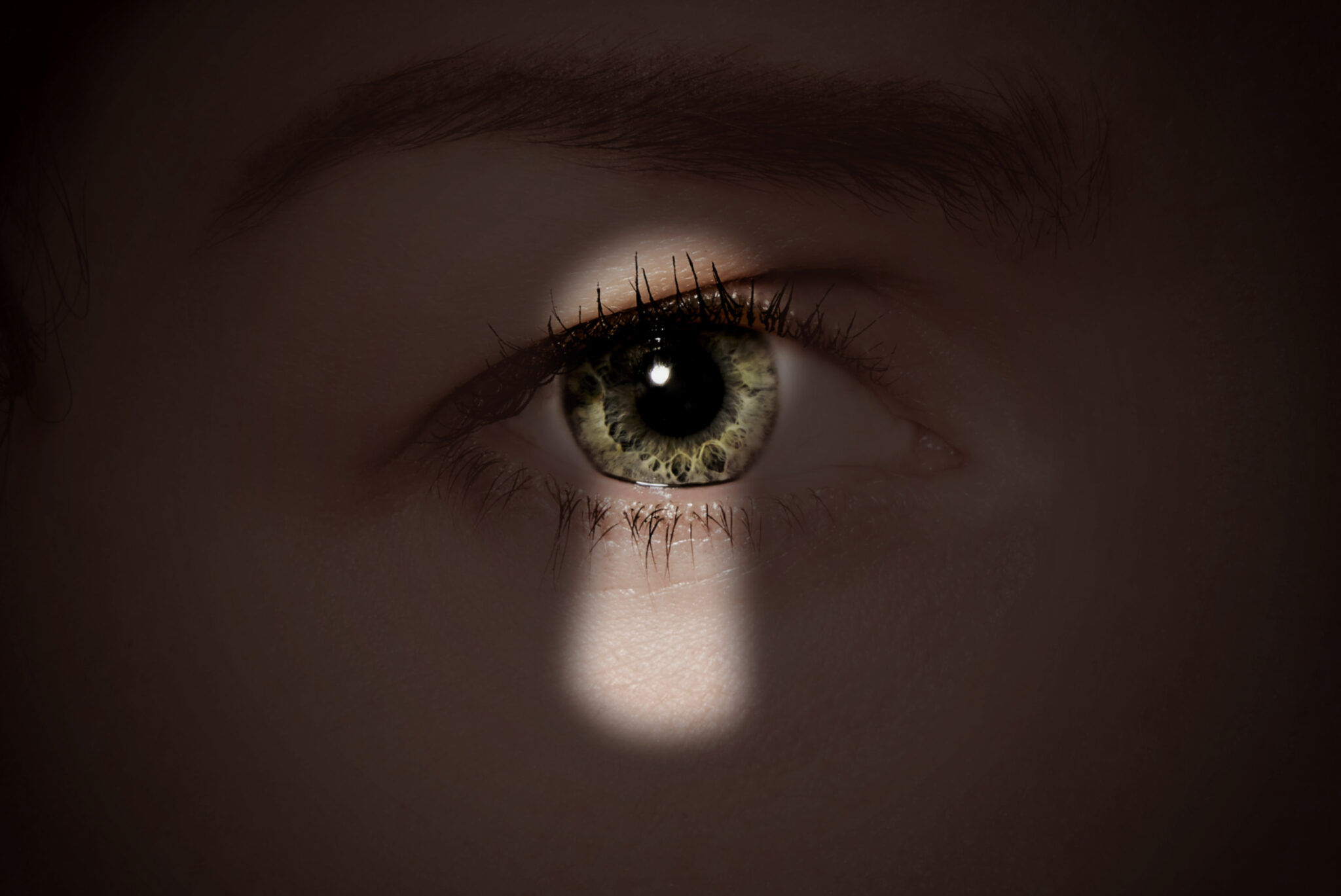 Skuggan av ett nyckelh&aring;l mot ett &ouml;ga.