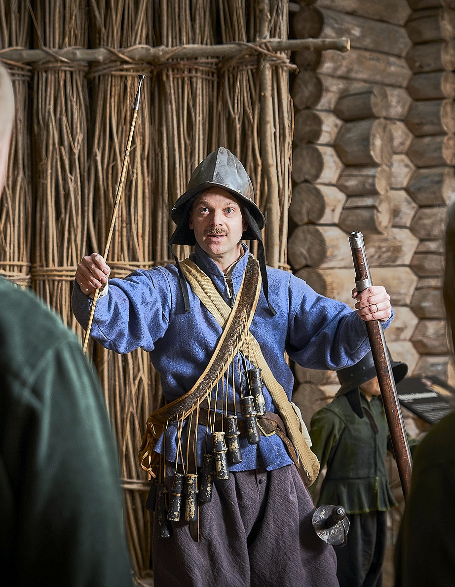 En person utf&ouml;r visning p&aring; museet if&ouml;rd tidstypiska kl&auml;der f&ouml;r stormaktstiden.