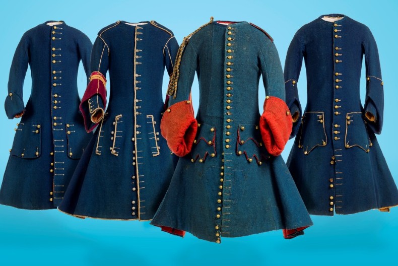 Fyra franska rockar, m&ouml;rkbl&aring;a med vidd nedtill och t&auml;tt med guldf&auml;rgade knappar fr&aring;n halsen och ner.
