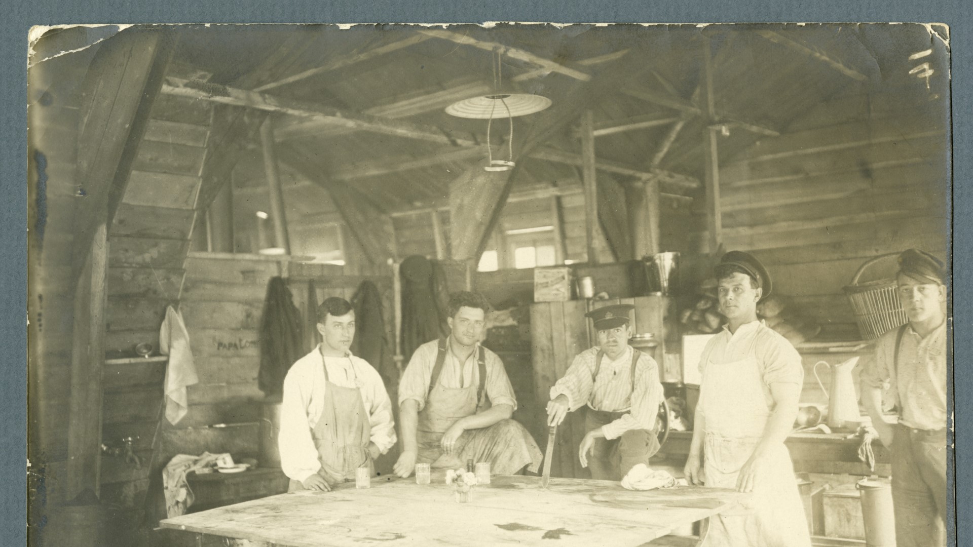 Fem vitkl&auml;dda sjukv&aring;rdare if&ouml;rda f&ouml;rkl&auml;den st&aring;r vid ett vitt bord i en timrad byggnad.