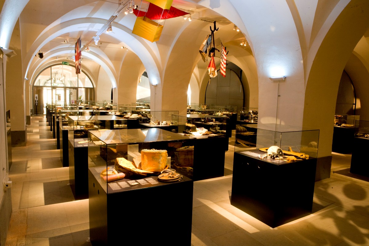 En utst&auml;llningshall med valv i taket och flera glasmontrar fyllda med diverse f&ouml;rem&aring;l.