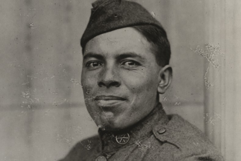 Portr&auml;tt av soldat if&ouml;rd hatt och uniform. Gr&aring; bakgrund.