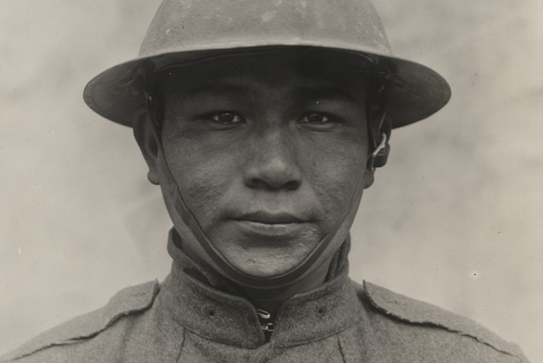 Portr&auml;tt av soldat if&ouml;rd hj&auml;lm och uniform. Gr&aring; bakgrund.