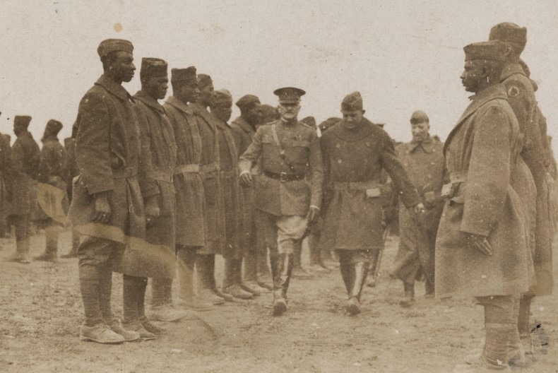 Uppst&auml;llda soldater p&aring; led och i mitten g&aring;r tre personer av h&ouml;gre rang fram.